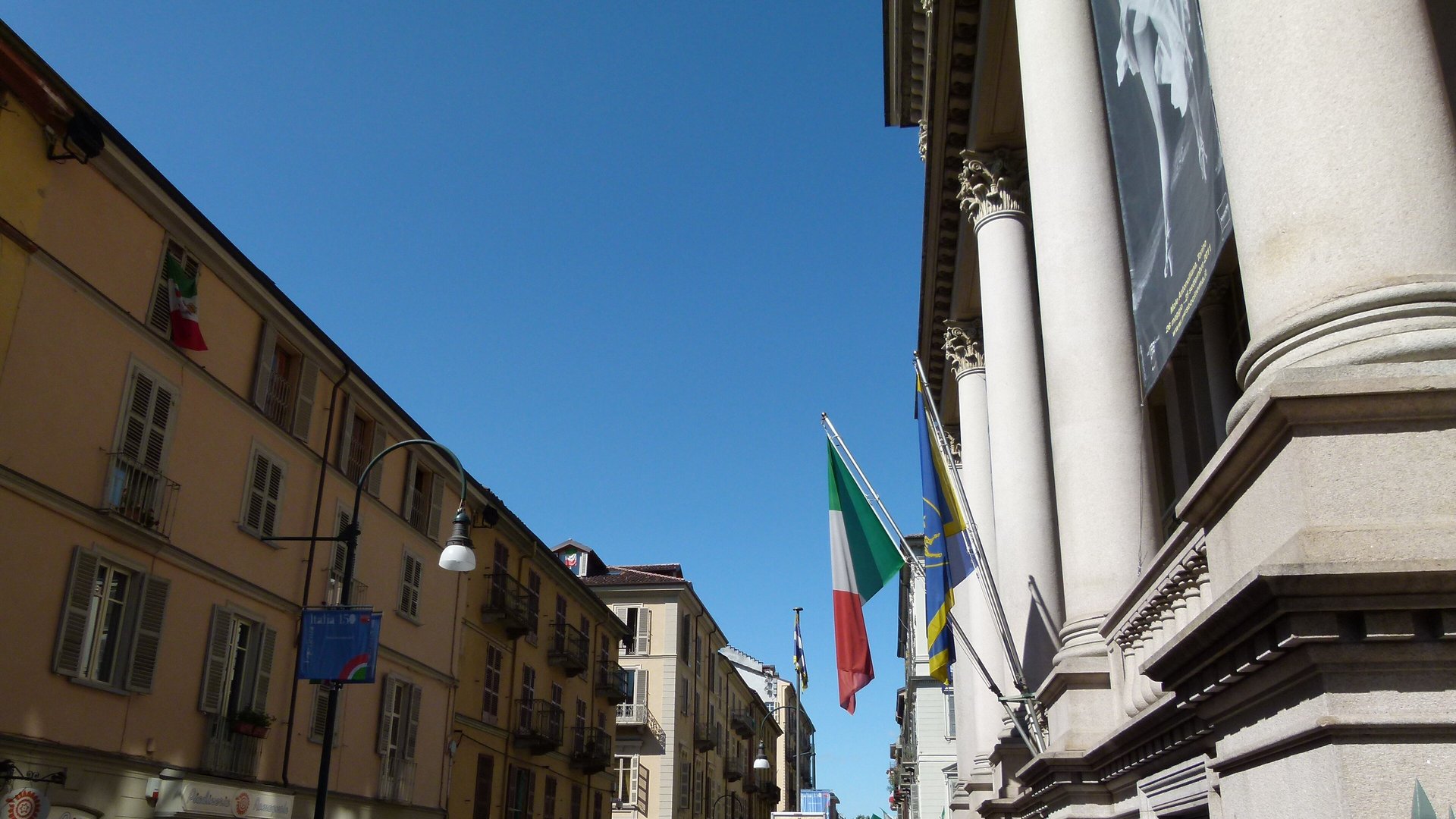 Ingresso della Mole Antonelliana in via Montebello a Torino con le bandiere sulla facciata