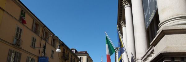 Ingresso della Mole Antonelliana in via Montebello a Torino con le bandiere sulla facciata